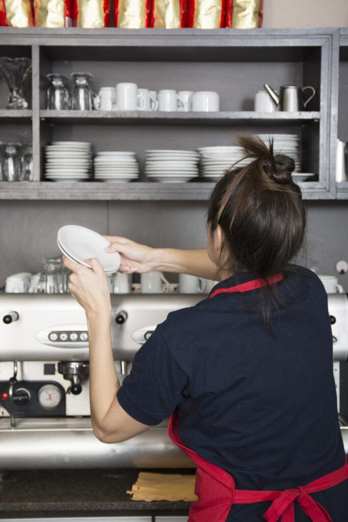 rear-view-female-barrister-arranging-saucers-shelves